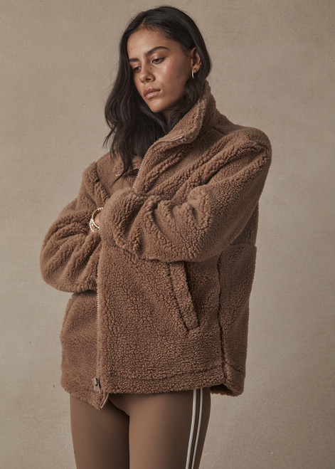 THE UPSIDE women's brown oversized Hudson Jacket made with faux shearling features a high neck collar with zipper, drawcord at waist and pockets. Fully lined, designed for winter.
