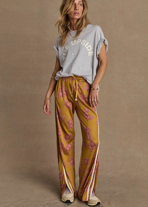 THE UPSIDE women’s floral Fantasy Roma Pant is a true-to-size fit and features an elasticated waistband with a drawcord, side pockets and cream side stripes. The perfect summer wardrobe piece.