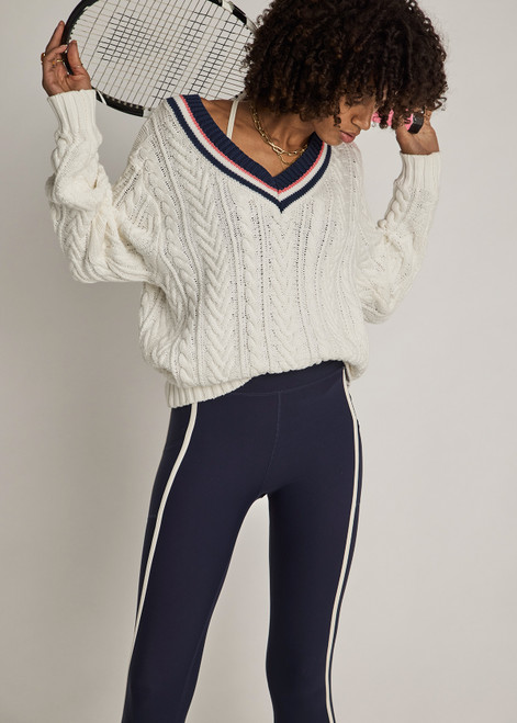 THE UPSIDE women’s cream organic cotton Espada Louie V Neck Sweater is a regular, chunky cable knit design with a navy and rose striped neckline. Made for everyday.