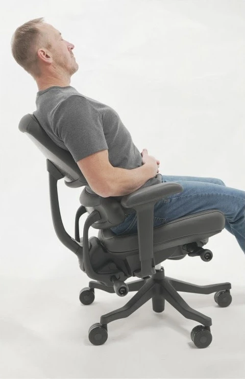 Person demonstrating recline in a dark Anthros ergonomic office chair