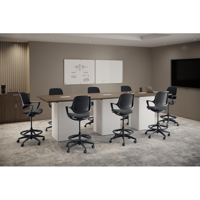 Black Konfurb Niro drafting stools with mesh backs and foot rings around a high office meeting table