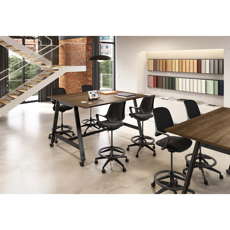 Black Konfurb Niro drafting stools at elevated worktables in a contemporary collaborative workspace