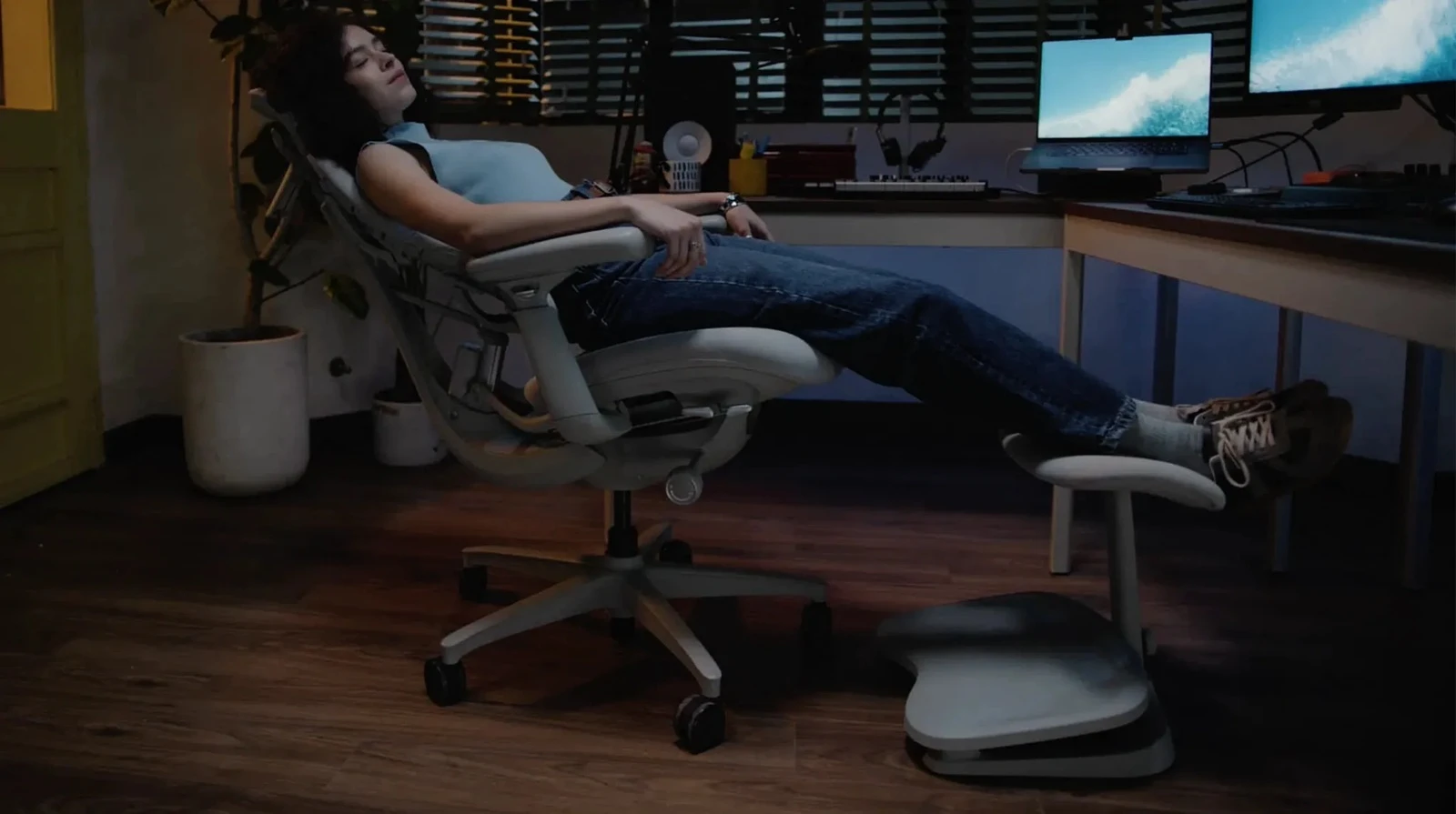 Person reclining in a LiberNovo Maxis chair with lower legs resting on the StepSync padded support