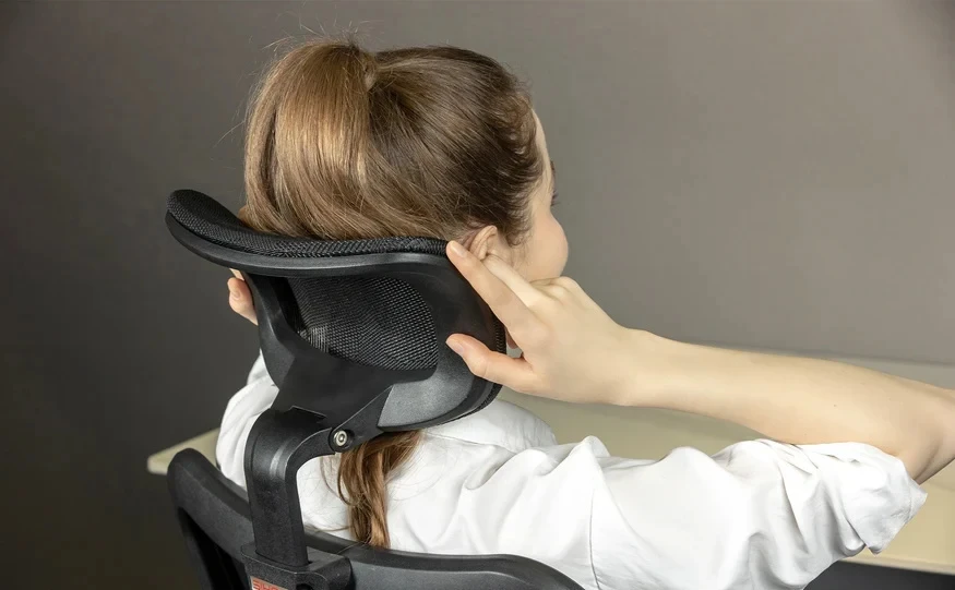 Seated person adjusting the height of the SIHOO M57 mesh headrest