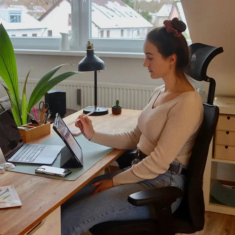 Person using a black SIHOO M57 mesh office chair at a home-office desk