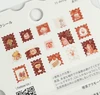 Close-up of the Cafe a la Mode & Post Office flake stickers - red postage-stamp shaped stickers of strawberry shortcake, roll cake, coffee grinder, teapot and breakfast plate