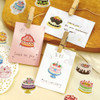 Cake stickers decorating small notes clipped to a string with clothespins