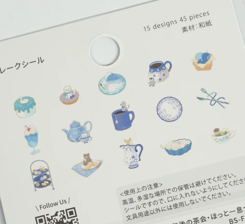 Close-up of the Afternoon Tea Party Have a Rest flake stickers - blue and white illustrations of teacups, teapots, cakes, a sleeping cat, penguin, bear and dessert parfaits