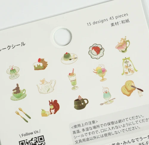 Close-up of the Afternoon Tea Party Sing a Song flake stickers - green and cream illustrations of a squirrel with acorns, a rabbit and mouse in teacups, a teapot, matcha parfaits and a tiered tea stand