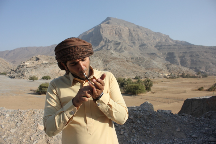 A person enjoying Dokha with a Medwakh pipe