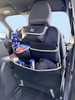 The Rear Single Seat Storage Organiser in Grey by OLPRO being fitted onto the rear of the passenger seat of VW vehicle with some products for children stored in it.