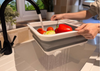 Image of OLPRO Collapsible Dish Drainer, being used for washing fruit and vegetables over a household sink in a modern kitchen.