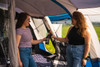 two friends talk & share a drink in the spacious living area of a Cocoon V2 Campervan Awning by OLPRO