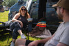 A man and a woman chat inside the Pershore Breeze® Campervan Canopy by OLPRO, They are both sat in a OLPRO camping chairs