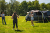 A group of friends play frisbee outside the Pershore Breeze® Campervan Canopy by OLPRO