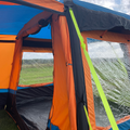 The Uno Breeze v2 Campervan Awning by Olpro photographed from outside the tunnel, showing a brightly coloured storm strap and open J door ,imageset:Orange