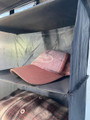 A close up of a Camping Organiser with Shelves and Storage Bag by OLPRO hanging in a campervan awning with a cap on the shelf.