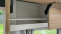 The telescopic cupboard & fridge storage bars being used inside of a Caravan