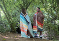 Tonal treetops and vivid spruce Insulated Outdoor Blanko been worn by a young couple enjoying the countryside with the outdoor blanket, wrapped around them. imageset:Vivid Spruce