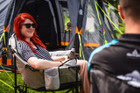 A male and a female sat on camping chairs outside of the Abberley Xl Breeze® 4 Berth Inflatable Tent from OLPRO.