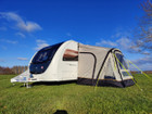 The OLPRO View Lite Breeze 260 Caravan Awning pictured attached to a caravan in a field.