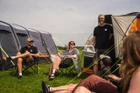 A small gathering of friends takes place between an OLPRO Wichenford 8.0 poled tent & Blakedown inflatable tent at a festival.