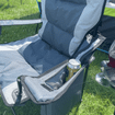 An image of a can of pop being stowed in the can holder of the Henwick Padded Folding Camp Chair - Grey & Charcoal from OLPRO outside of a tent.