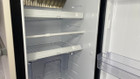 The telescopic cupboard & fridge storage bars being used within a fridge of a caravan.