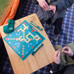 Image of OLPRO Bamboo Camping Table in a campervan awning, with a Scrabble board game on top.
