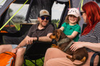 A young family sit outside the Discovery 6 Berth Inflatable Tent on a campsite