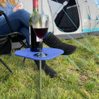 Image of OLPRO Camping Spike Stick Table outside a tent, with a glass of wine on top.