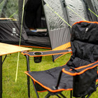 Close up Image of Henwick Padded Folding Camp Chair Orange & Black by OLPRO with the bamboo table outside a tent.