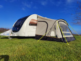 An image of the View Lite 390 Caravan Awning from OLPRO attached to a caravan in a field.