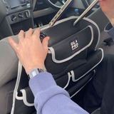 The Rear Single Seat Storage Organiser in Grey by OLPRO being fitted onto the rear of the passenger seat of VW vehicle.