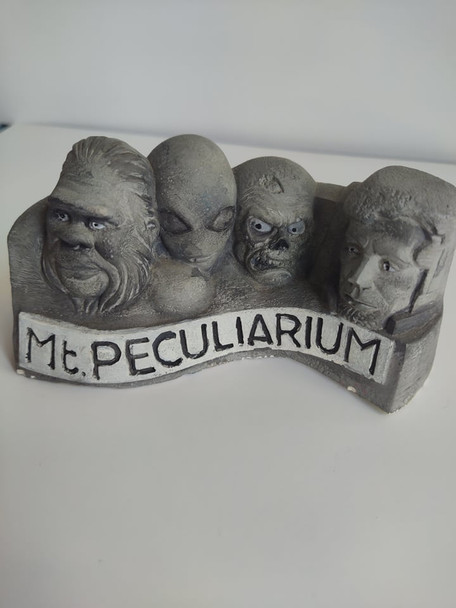 Molded sculpture of Colin Batty's version of Mt. Rushmore, complete with Bigfoot, Aliens, Skull, and Astronaut.