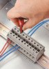 Using the Milwaukee 48-22-2604 to secure a small wire in an electrical terminal block.