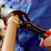 Knipex 8701250 10-inch Cobra High-Tech Water Pump Pliers gripping a plumbing pipe fitting for installation and repair.