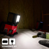 Milwaukee 2368-20 M18 ROVER Triple-Panel Flood and Area Light powered by extension cord on workbench.