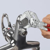 Knipex Mini Pliers Wrench tightening a chrome plumbing fitting using smooth parallel jaws that protect plated surfaces from marring.
