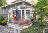 Homeowner using STIHL BG 50 handheld gas leaf blower to clear leaves and debris from a backyard deck and patio area.