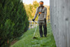 STIHL FA082000007 cordless brushcutter with loop handle trimming tall grass on a sloped landscape, providing efficient battery-powered vegetation management.