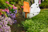 Close-up of the STIHL FSA 30-1S cordless trimmer creating clean lawn edges along flower beds with its adjustable trimmer head and spacer bar.