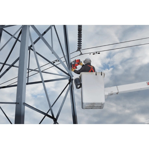 A lineman using the 2788-22HD to drill a 1" hole in an I-beam on a power pole project.