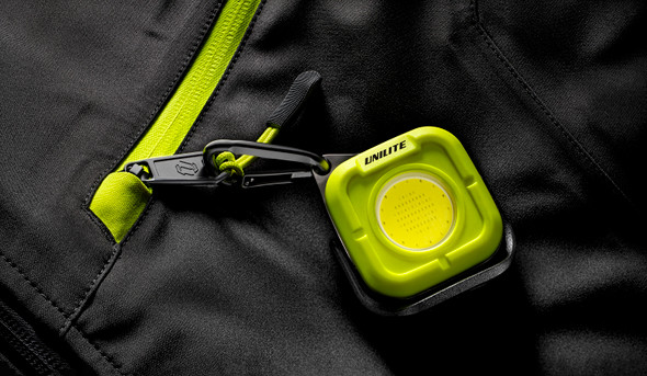 Unilite K-550 showing its integrated carabiner clipped to a tool bag or belt loop.