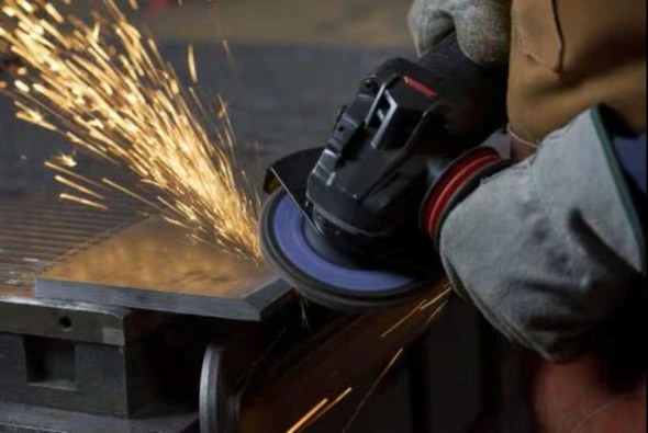 3M™ Cubitron™ 3 1169F Type 27 flap disc mounted on an angle grinder beveling structural steel with fast stock removal, long abrasive life, and consistent cutting performance.