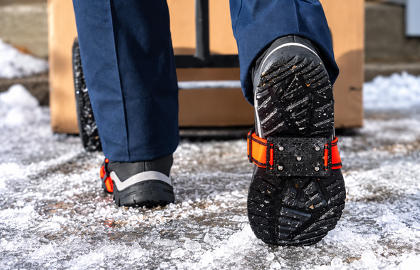 K1 Mid-Sole Hi-Viz Low Profile Ice Cleat fitted to a work boot for traction while walking on snow and ice.