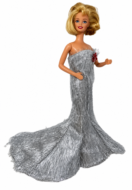 Side view Blonde fashion doll wearing a shimmering metallic silver strapless gown with a dramatic long mermaid-style train and red flower accent. Elegant formal dress fits 11.5-inch fashion dolls, displayed against a glamorous red and gold background with sparkling lights. Doll Clothes Superstore.