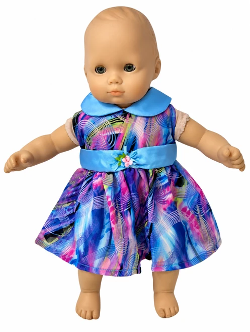 Font view Baby doll wearing a colorful blue, purple, and pink swirl-print dress with a light blue Peter Pan collar, matching satin waistband, and pink floral accent. Handmade doll dress features a gathered skirt, displayed against a cheerful pastel floral background. Doll clothes from Doll Clothes Superstore.