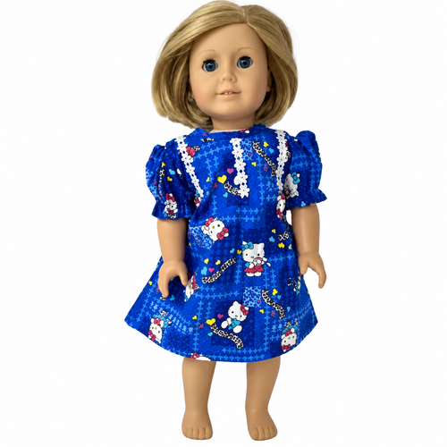 Front view Adorable blonde 18-inch girl doll wearing a handmade deep blue kitten-print nightgown with puff sleeves, white lace trim, colorful hearts, and cute kitten designs. Cheerful Pinterest pin features a cozy pink bedroom, moon and stars, a close-up of the nightgown, and a sleeping kitten illustration. Handmade doll pajamas from Doll Clothes Superstore, designed to fit 18-inch girl dolls