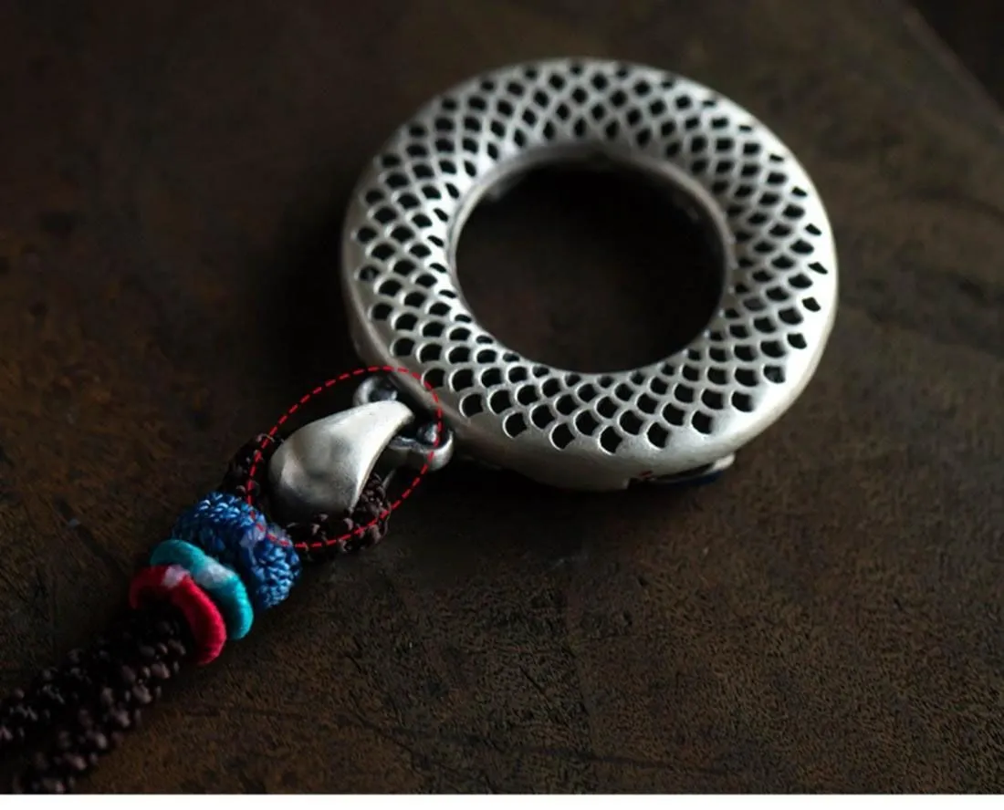 Close-up of hand-painted enamel detail on copper pendant back view